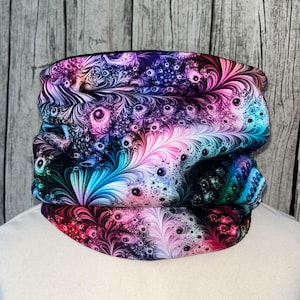 Peut inclure: Un tour de cou noir avec un motif abstrait coloré composé de volutes, de points et de plumes dans des tons de rose, bleu, vert et violet.