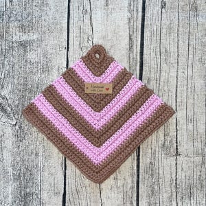 Może przedstawiać: Brązowa i różowa dziana podkładka pod gorące z brązową metką z napisem "Handmade with Love" i różowym sercem.