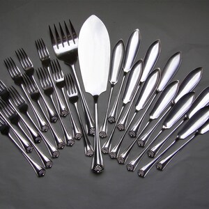 May include: A set of silver-plated cutlery, including a serving knife and a collection of forks and butter knives.