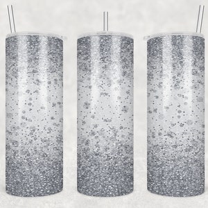 May include: Three silver glitter tumblers with lids and straws. The tumblers have a gradient of silver glitter, with more glitter at the bottom and less glitter at the top.