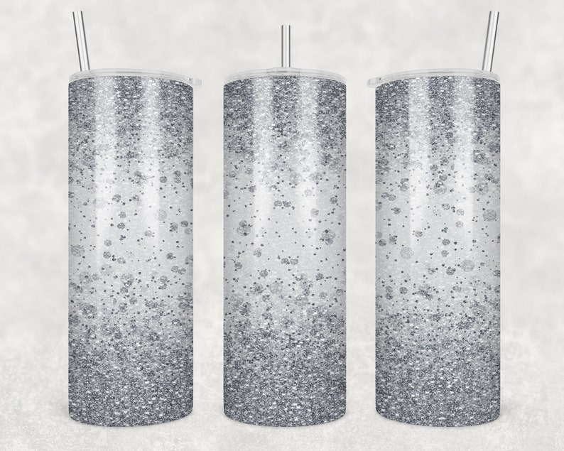 May include: Three silver glitter tumblers with lids and straws. The tumblers have a gradient of silver glitter, with more glitter at the bottom and less glitter at the top.
