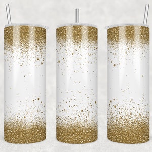 May include: Three stainless steel tumblers with a white background and a gold glitter ombre design. The tumblers have lids and straws.