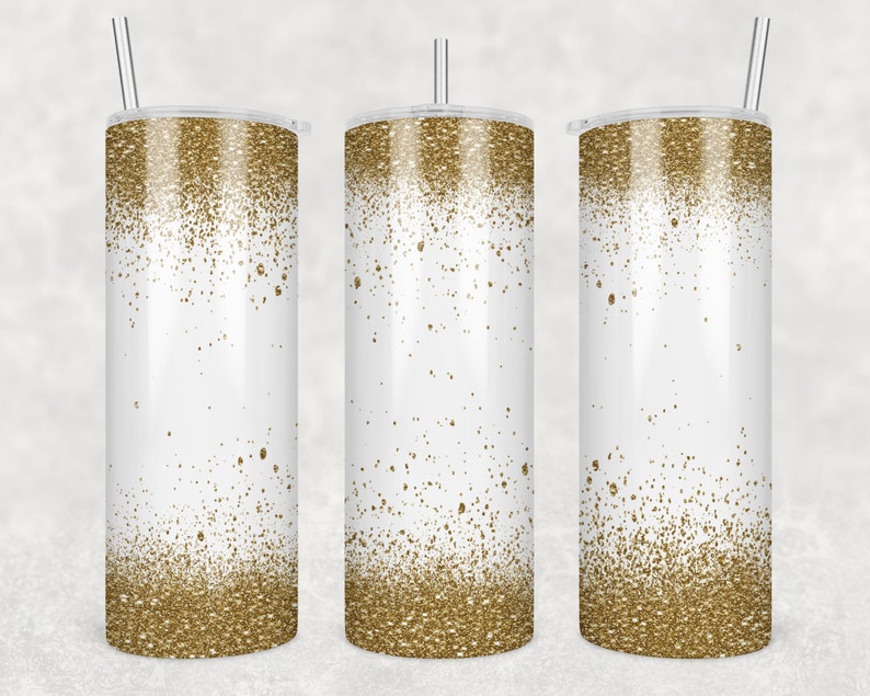 May include: Three stainless steel tumblers with a white background and a gold glitter ombre design. The tumblers have lids and straws.