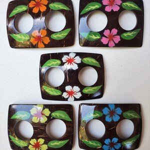 May include: Five wooden toggles with two holes each. The toggles are painted with a dark brown background and feature different floral designs with colors like pink, orange, yellow, white, and blue.