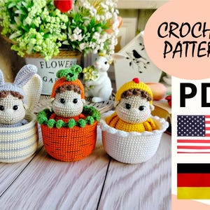 Op de afbeelding: Haakpatroon PDF voor drie amigurumi poppen: een konijn, een pompoen en een kuiken. De poppen zitten in gehaakte manden. Het patroon is beschikbaar in het Engels en Duits.