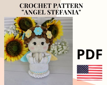 May include: Crochet pattern for an angel named Stefania. The pattern is available as a PDF download. The image shows a crocheted angel doll with brown hair, a white dress, and blue and yellow flowers in her hair. The doll is standing on a wooden surface with sunflowers in the background.