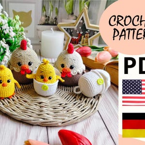 Könnte beinhalten: Häkelanleitung PDF zum Herstellen von Amigurumi-Küken und einem Küken im Ei. Die Anleitung ist in Englisch und Deutsch verfügbar. Das Bild zeigt vier gehäkelte Küken, eines in einem weißen Ei und einen Weidenkorb.