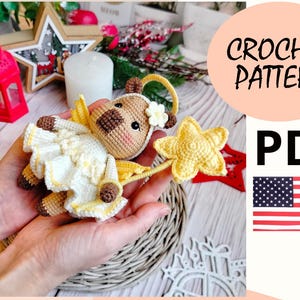 May include: Crochet pattern PDF for a cute amigurumi angel with a star. The angel is wearing a white dress with yellow accents and has a brown face. The pattern is available in PDF format and includes instructions for crocheting the angel.