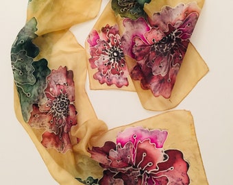 May include: A beige silk scarf with a floral pattern. The flowers are painted in shades of pink, red, green, and black.