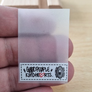 May include: A clear sticker with a white label that says "Good People" with a red heart and "Kindhearts." The label also has a black and white logo with the text "Worldwide Real Gang."