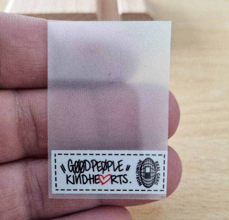 May include: A clear sticker with a white label that says "Good People" with a red heart and "Kindhearts." The label also has a black and white logo with the text "Worldwide Real Gang."