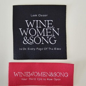 Pu&ograve; includere: Un'etichetta quadrata in tessuto nero con testo ricamato in bianco Look Closer WINE WOMEN & SONG Is On Every Page Of Tha Bible, e un'etichetta rettangolare rossa con testo bianco WINEWOMEN&SONG Your Third Eye Is Now Open.