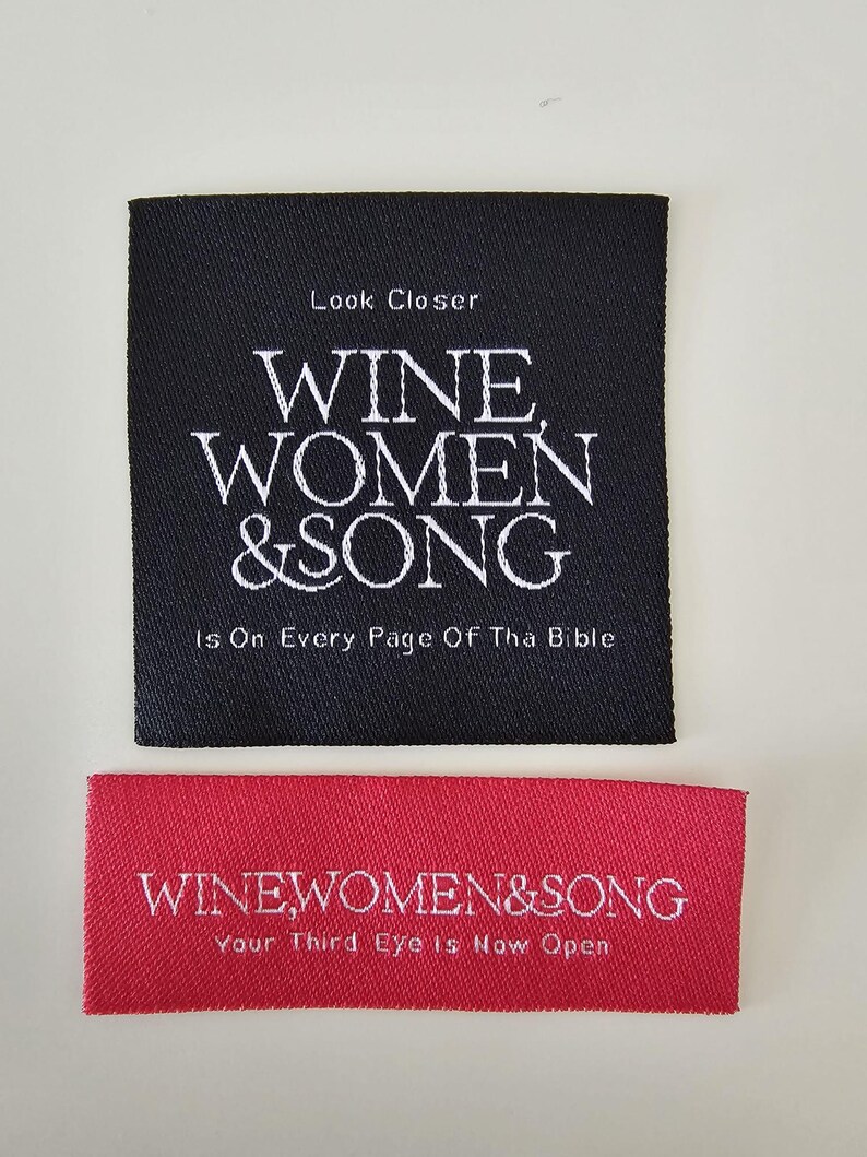 Pu&ograve; includere: Un'etichetta quadrata in tessuto nero con testo ricamato in bianco Look Closer WINE WOMEN & SONG Is On Every Page Of Tha Bible, e un'etichetta rettangolare rossa con testo bianco WINEWOMEN&SONG Your Third Eye Is Now Open.