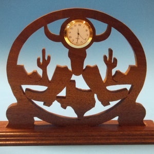 May include: A wooden clock with a cutout design of a Texas state silhouette, a longhorn steer head, and cacti. The clock face is round and has gold-colored hands and numbers.