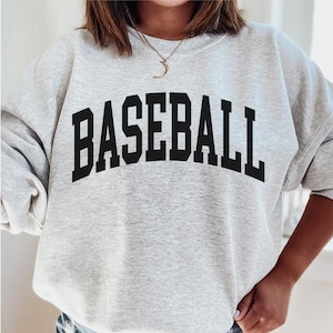 May include: A grey sweatshirt with the word "BASEBALL" printed in black on the front.