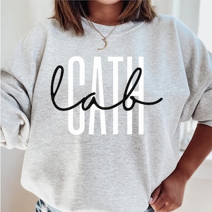 May include: A gray sweatshirt with the word "lab" written in black cursive script over a white background.