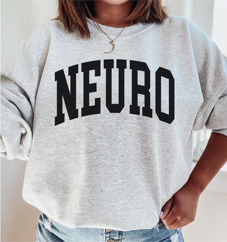 K&ouml;nnte beinhalten: Ein graues Sweatshirt mit dem Wort "NEURO" in schwarzen Blockbuchstaben.