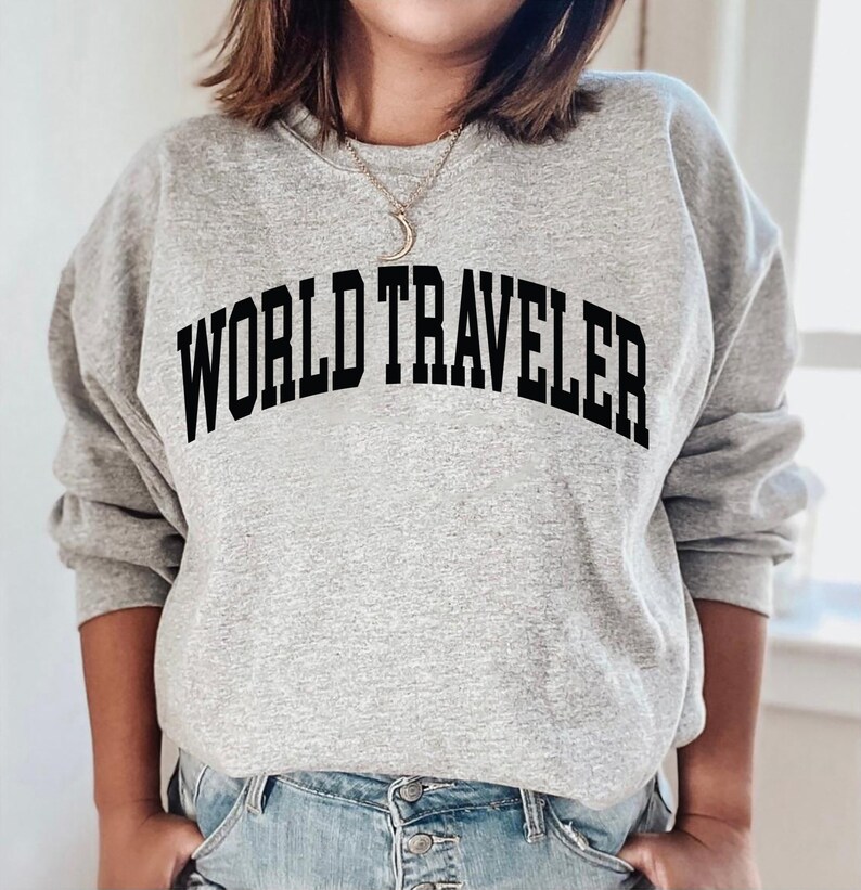 May include: A gray sweatshirt with the text "WORLD TRAVELER" printed in black.
