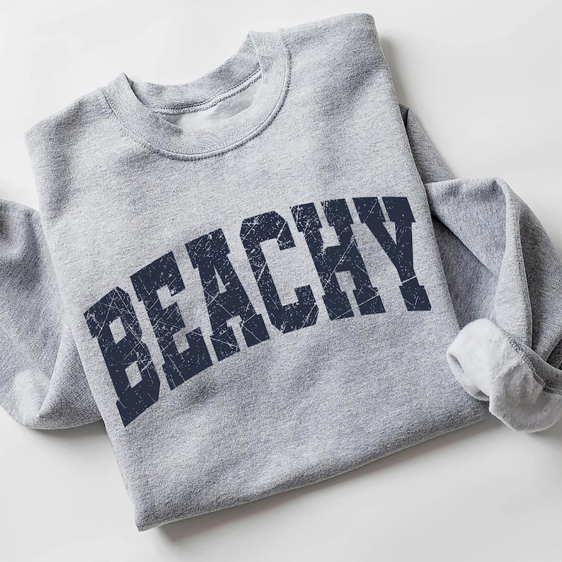 May include: Gray sweatshirt with a navy blue distressed graphic that says "Beachy".