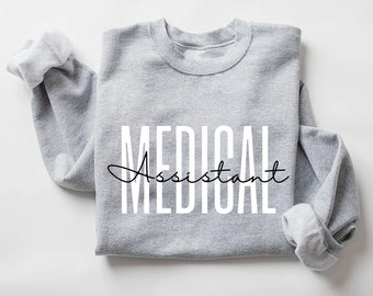 May include: A grey sweatshirt with the text "MEDICAL Assistant" printed in white letters.