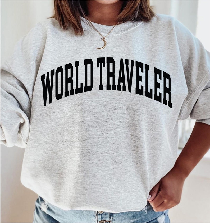 May include: Gray sweatshirt with the text "WORLD TRAVELER" in black.