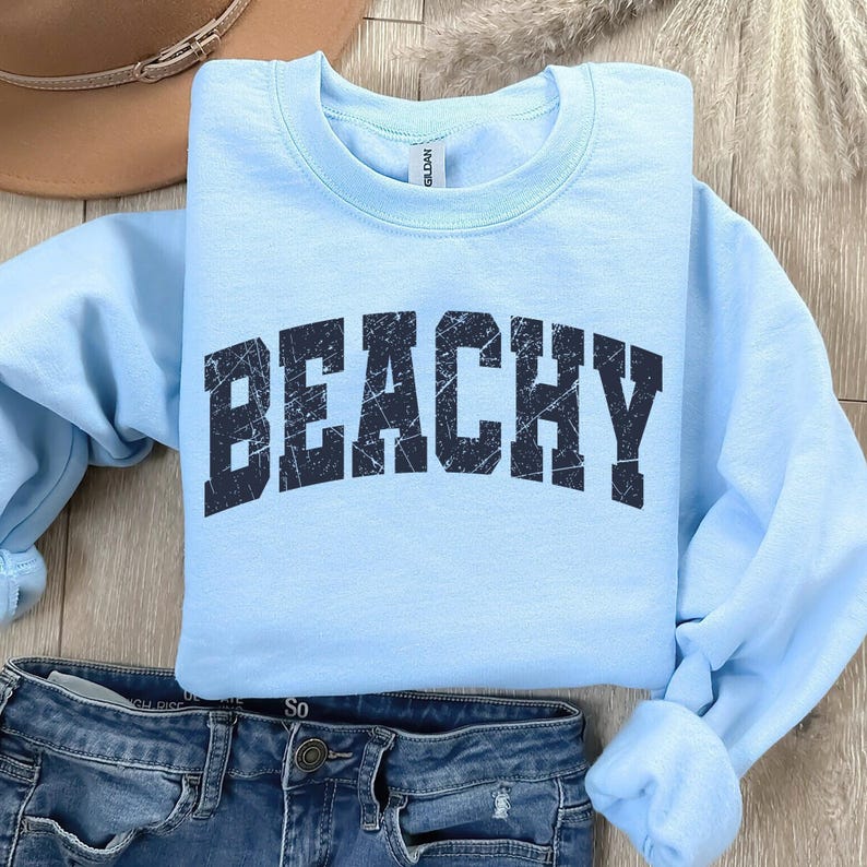 May include: Light blue sweatshirt with the word "Beachy" printed in black distressed lettering.