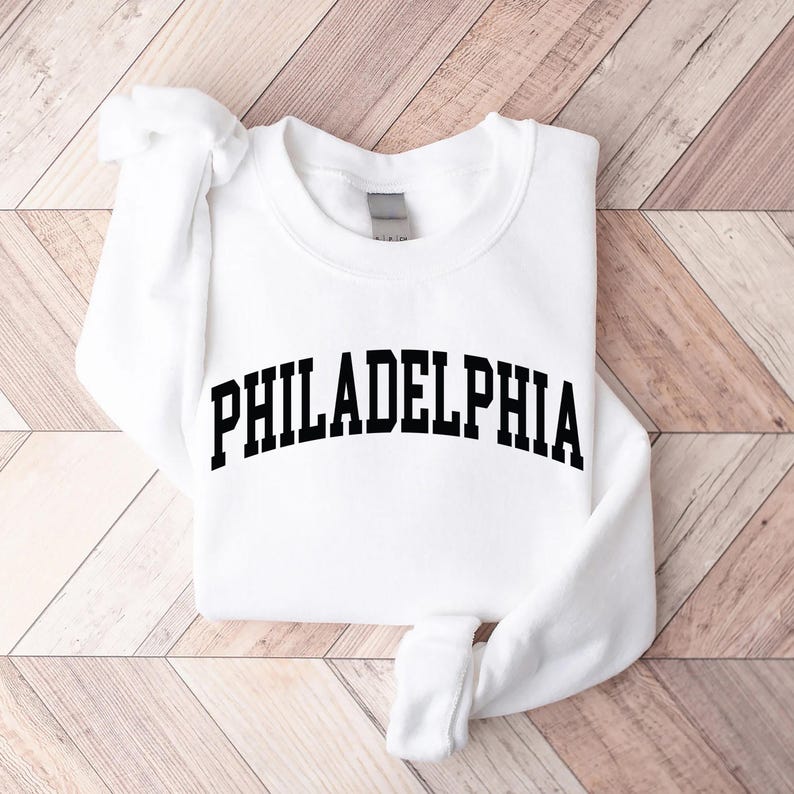 May include: White sweatshirt with black text that reads "PHILADELPHIA" in an arched font.
