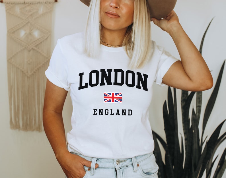 May include: White t-shirt with black text that says "LONDON" and "ENGLAND" with a small Union Jack flag in between the words.