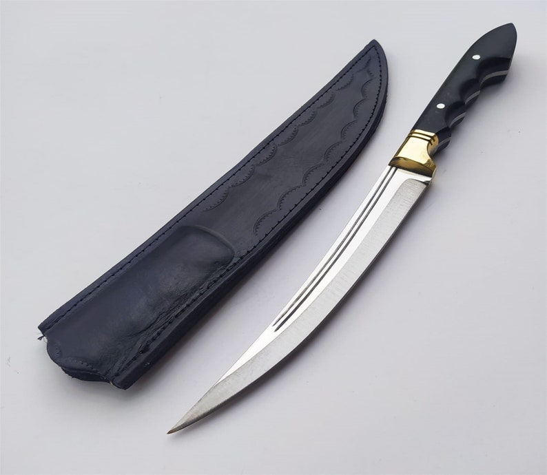 May include: A black leather sheath with a silver blade knife with a black handle and gold accents.