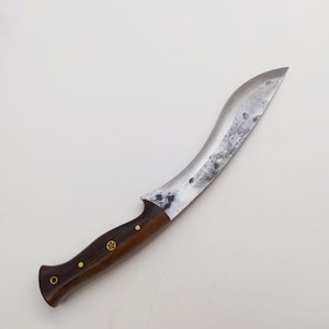May include: A curved, silver-colored knife with a dark brown wooden handle. The handle has brass accents.