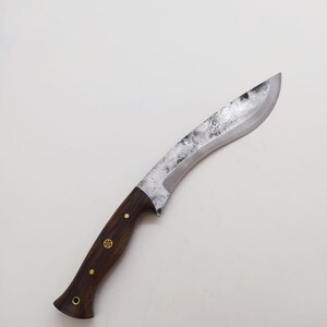 May include: A curved, silver-colored knife with a dark brown wooden handle. The handle has brass accents.