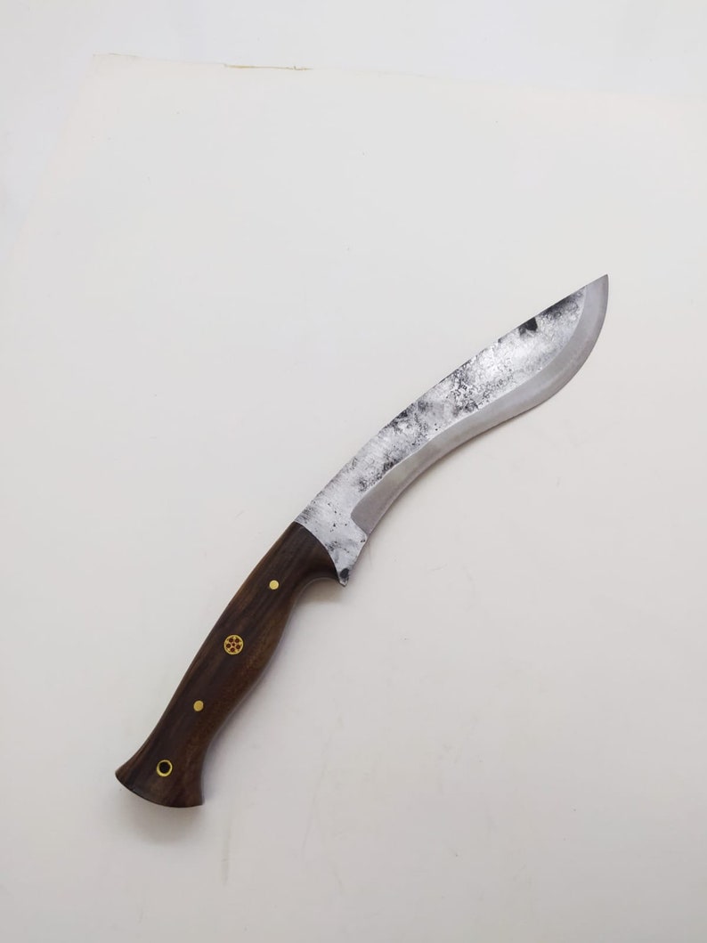May include: A curved, silver-colored knife with a dark brown wooden handle. The handle has brass accents.