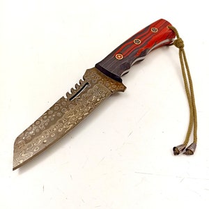 May include: A hunting knife with a black and red handle and a patterned blade. The knife has a lanyard attached to the handle.