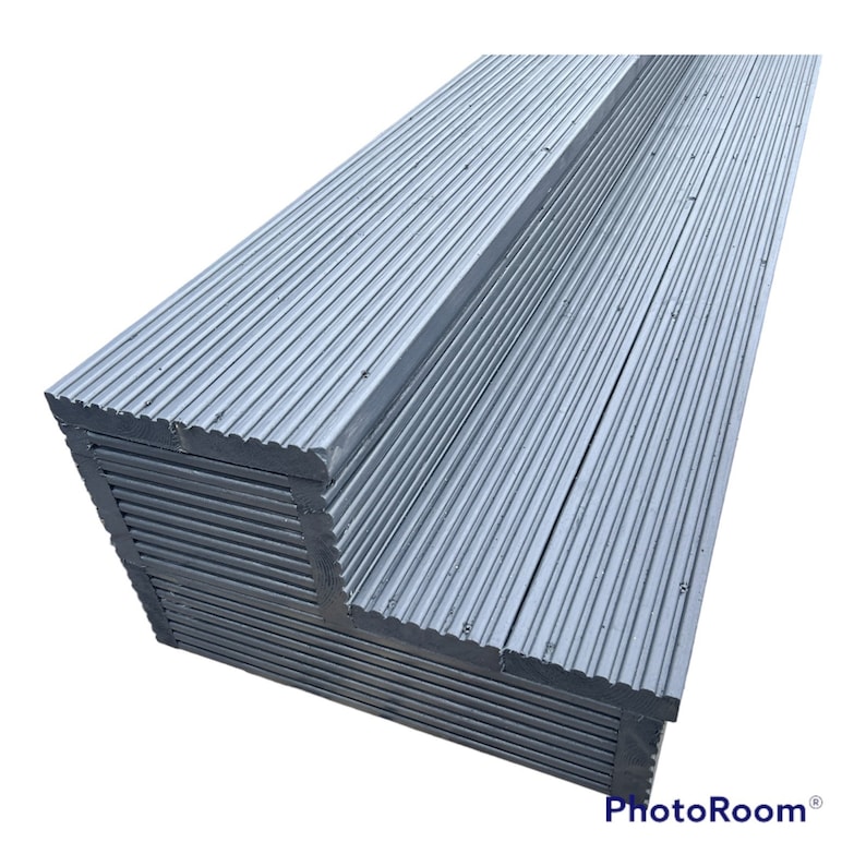 May include: A stack of gray composite decking boards with a grooved surface. The boards are arranged in a corner shape.