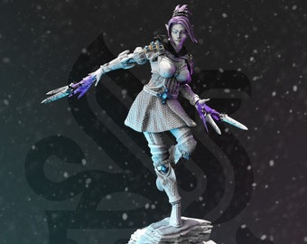 Puede incluir: Una figura pintada de blanco de un personaje femenino con cabello morado y un atuendo blanco y gris. Ella sostiene dos dagas en sus manos. La figura está de pie sobre una base de roca gris.