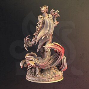 May include: A detailed figurine of a warrior in ornate armor, cape, and helmet. The figure is posed dynamically, with flowing fabric and a base with intricate details. The color palette is primarily neutral with red accents.