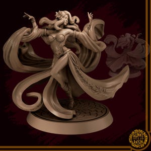 May include: A tan-colored figurine of a woman in a flowing gown, arms outstretched in a dance pose. The figure is on a circular base with a floral design. The woman has long flowing hair and a flower in her hair.