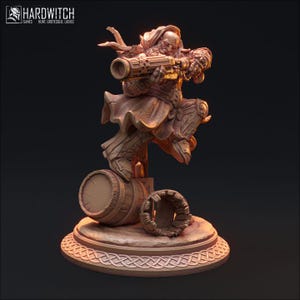 May include: A miniature figurine of a dwarf holding a gun, standing on a barrel. The dwarf is wearing a hooded cloak and has a beard. The figurine is painted in a bronze color.