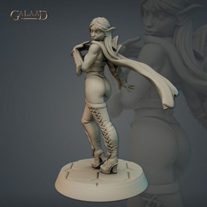 Peut inclure: Une figurine miniature grise et détaillée d'une guerrière elfe féminine aux oreilles pointues, vêtue d'une tenue en cuir, de bottes et d'une cape flottante. La figurine est debout sur une base circulaire avec une surface texturée.