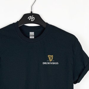 May include: Black t-shirt with a gold Guinness harp logo and the text "DRUM N BASS" underneath.
