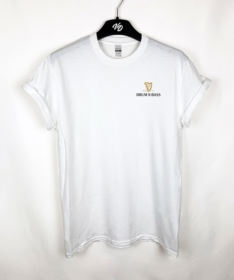 May include: White t-shirt with a gold harp logo and the text "DRUM N BASS" printed on the front.