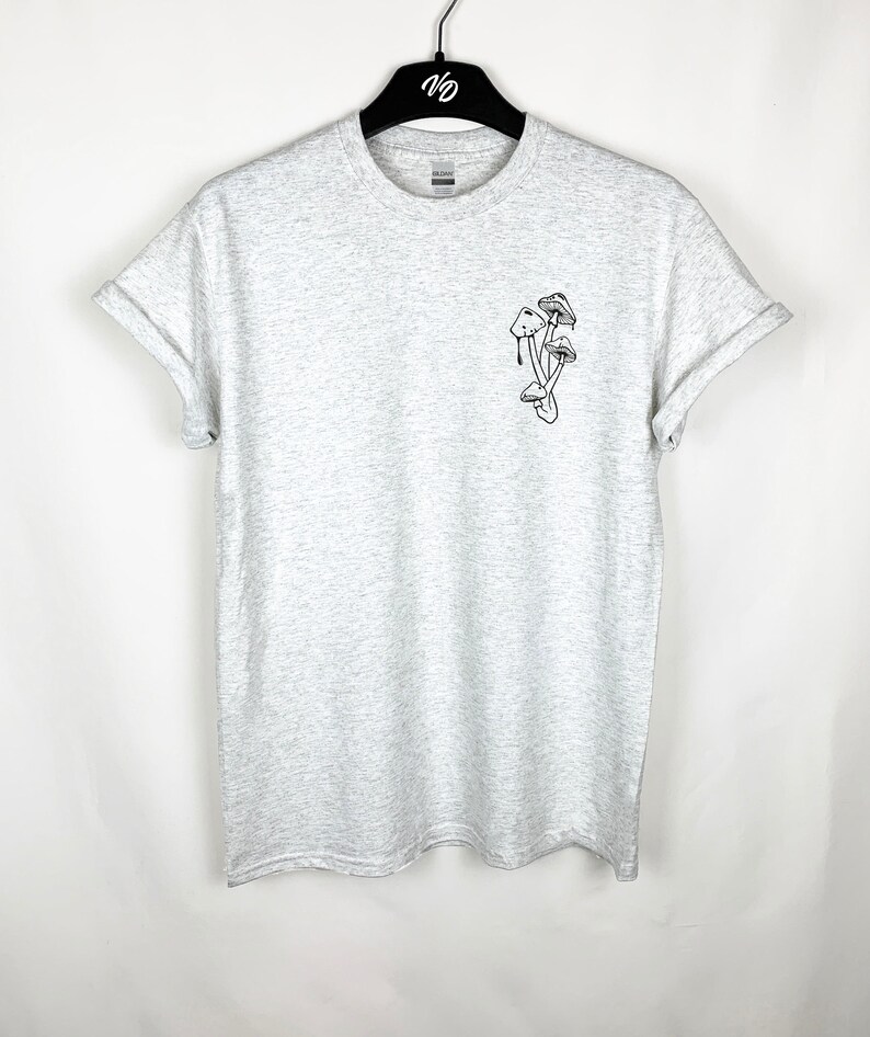 Puede incluir: Una camiseta gris jaspeada con una ilustraci&oacute;n en blanco y negro de setas en la parte delantera.