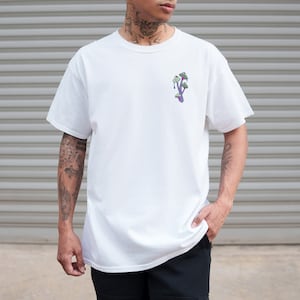 Peut inclure: T-shirt blanc avec un motif de champignons violets sur le devant.