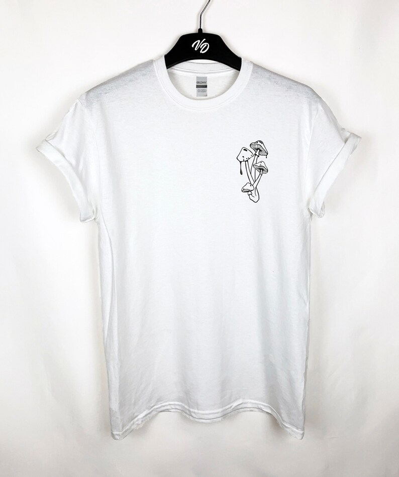 Puede incluir: Camiseta blanca con un dibujo de l&iacute;nea negra de setas en el pecho izquierdo.