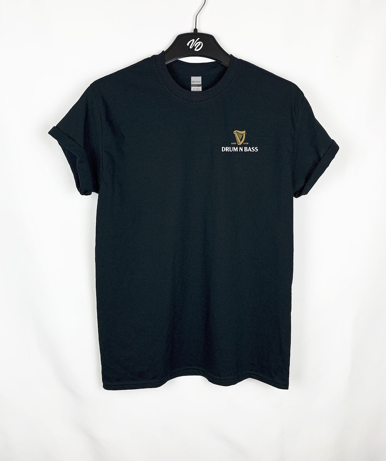 May include: Black t-shirt with a gold Guinness harp logo and the text "DRUM N BASS" underneath.