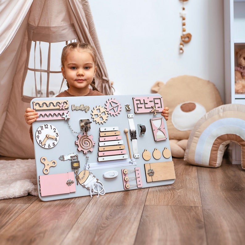 a little girl is holding up a large clock