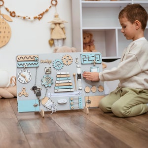 a young boy playing with a wooden clock