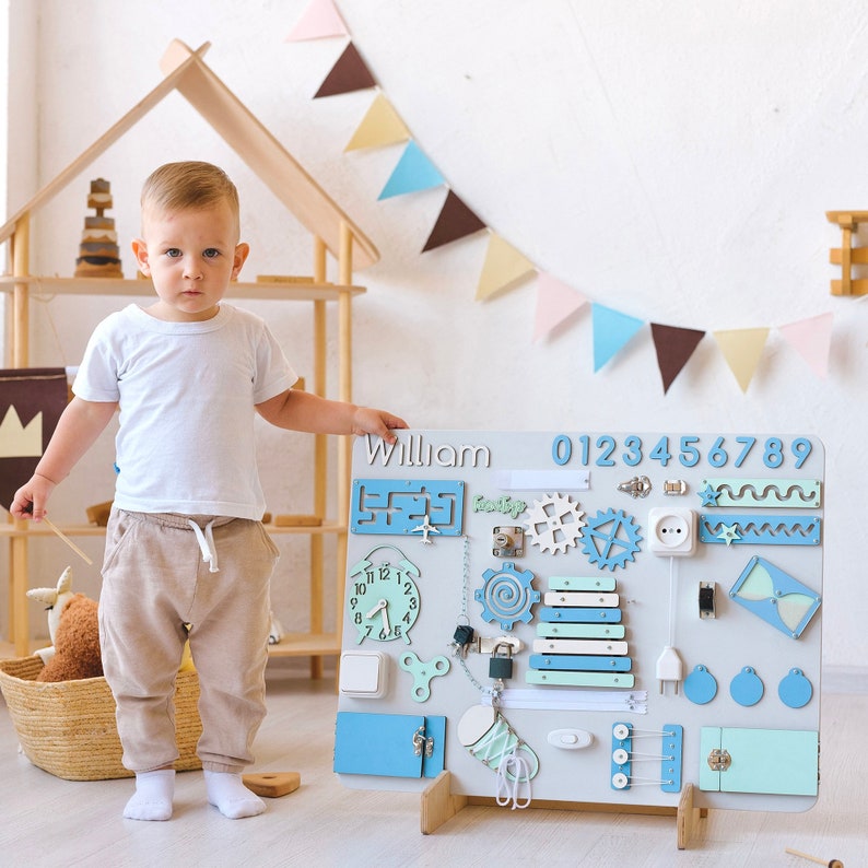 a little boy standing next to a toy clock