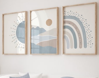 May include: Three framed wall art prints featuring abstract designs in muted blue, beige, and white tones. The left print shows a sun, the center print depicts a landscape with a circle, and the right print displays a rainbow with dotted accents.