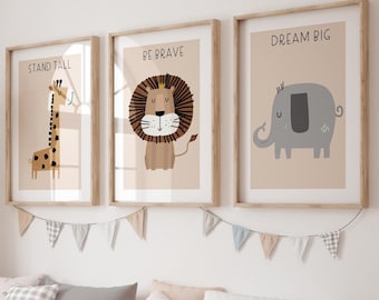 May include: Three framed art prints with animal illustrations and inspirational phrases: "STAND TALL" with a giraffe, "BE BRAVE" with a lion, and "DREAM BIG" with an elephant. The prints are in a child's room with a woven giraffe statue and storage bench.